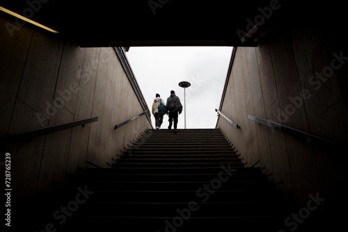 Two boys from behind emerge from an underground subway tunnel.