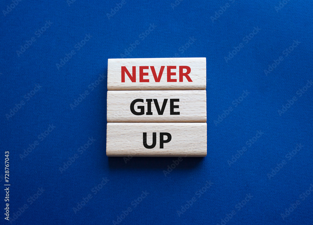 Never give up symbol. Concept words Never give up on wooden blocks. Beautiful deep blue green background. Business and Never give up concept. Copy space. Never give up symbol. Concept words Never give up on wooden blocks. Beautiful deep blue green background. Business and Never give up concept. Copy space.