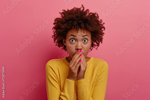 Nervous African American school girl and biting nails in studio with oops reaction to gossip on pink background. Mistake  sorry  drama or secret with regret  shame or awkward