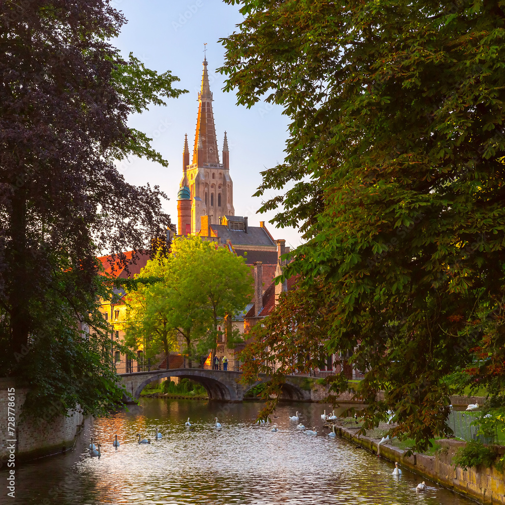 Scenic cityscape with medieval fairytale Church of Our Lady in Bruges at sunset, Belgium