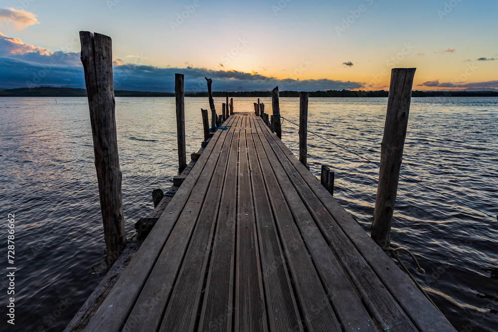 Path over the wooden pier, with a beautiful view of Vitória Bay and the Espírito Santo mountains during a peaceful late afternoon