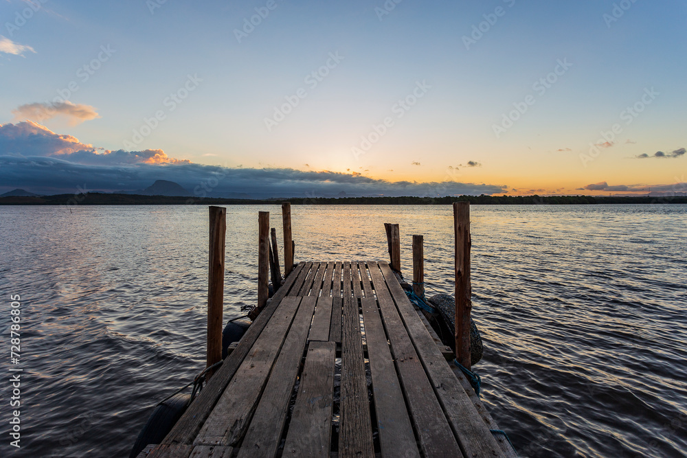Path over the wooden pier, with a beautiful view of Vitória Bay and the Espírito Santo mountains during a peaceful late afternoon