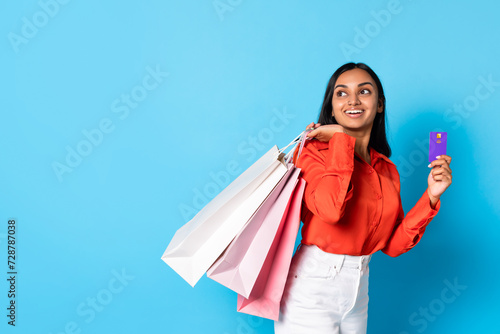 hindu customer lady holding credit card and shopper bags, studio