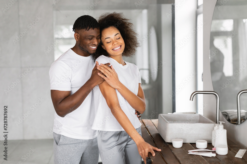 Loving Black Husband Hugging Happy Beautiful Wife In Modern Bathroom