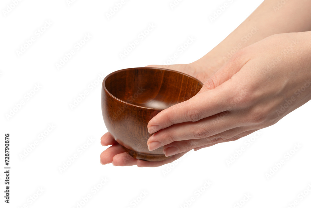 Female hand is holding a wooden bowl isolated on a white background. Female hand is holding a wooden bowl isolated on a white background.