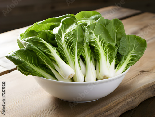 Fresh green bak choy cabbage in a white bowl on kitchen. table photo