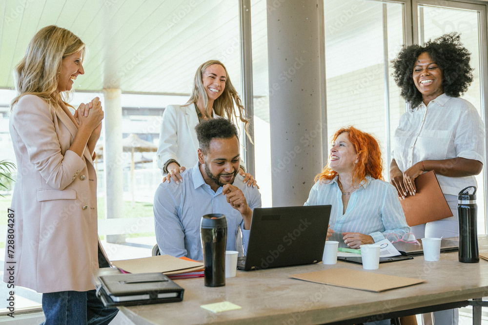 Multiethnic business colleagues smiling while enjoying time together at the office. Multiethnic business colleagues smiling while enjoying time together at the office.