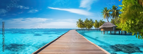 Dock leading to tropical beach with palm trees. © Marharyta