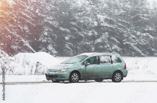 Car on a winter road. Dangerous driving conditions on the highway. Winter tires and undercarriage rust and corrosion concept. Slippery highway.
