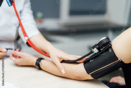 Doctor measuring blood pressure of patient photo