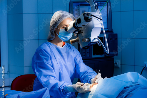 Female surgeon is operating in surgical room woman is looking in microscope nurse is adjusting sterile mask