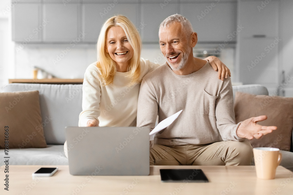Happy mature man and woman paying bills online Happy mature man and woman paying bills online