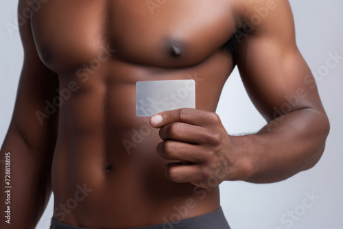 muscular African male hand holding up a blank white card, set against a neutral background for a bold statement