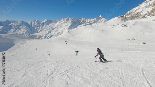 Follow woman skiing downhill on a ski slope in Cervinia ski resort, Italy