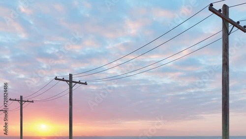 A close-up view of multiple electricity poles and cables at sunset.