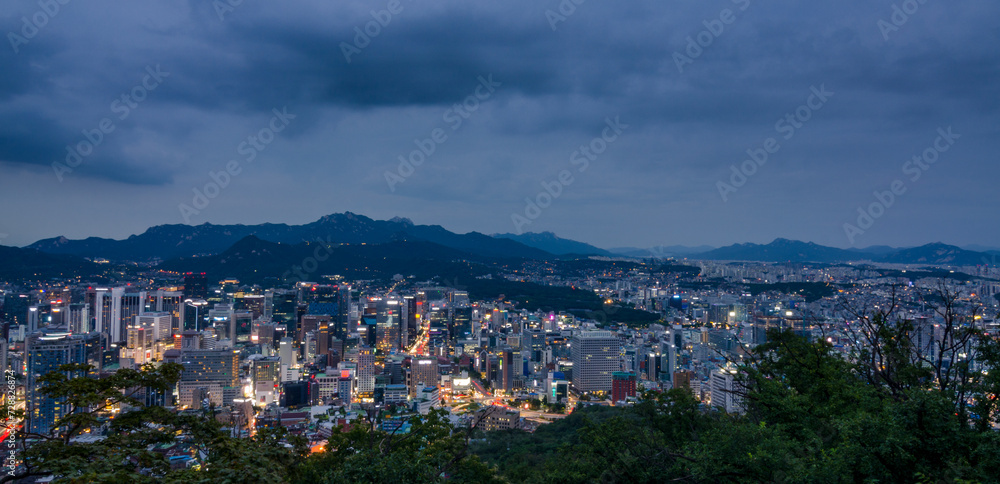 Seoul, South Korea cityscape during a dusk with mountains in a background.