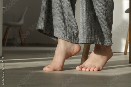 Barefoot woman on the wooden floor. Concept of the underfloor heating in the apartment.