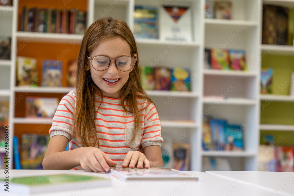Brown haired sitting school library reading preparing for lessons. Brown haired sitting school library reading preparing for lessons.