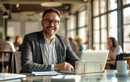 Cheerful Businessman with Glasses at a Modern Office Desk