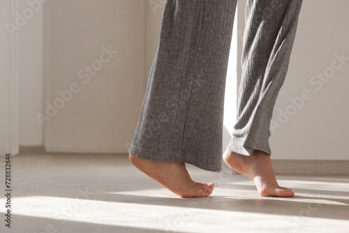 Barefoot woman on the wooden floor. Concept of the underfloor heating in the apartment. photo
