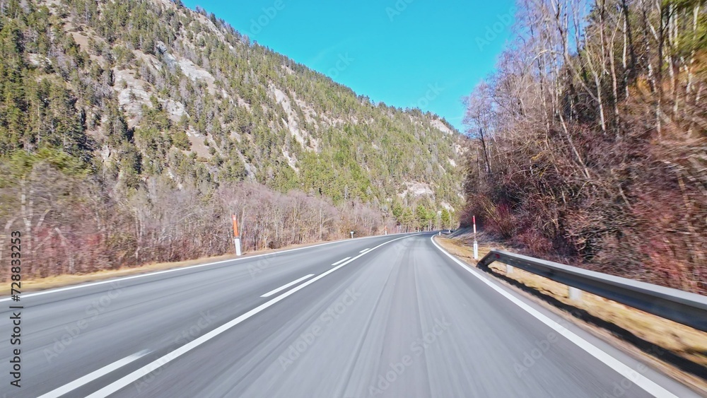Fototapeta premium Dash Cam POV Car Driving Down Asphalt Road Through Austrian Alps Valley