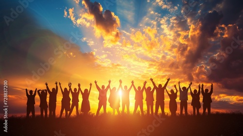 Silhouettes of a Crowd with Hands Raised Toward a Glowing Sunset Sky