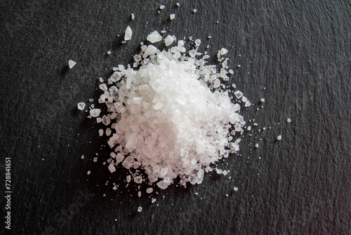 White salt cristals for food on the black background. photo