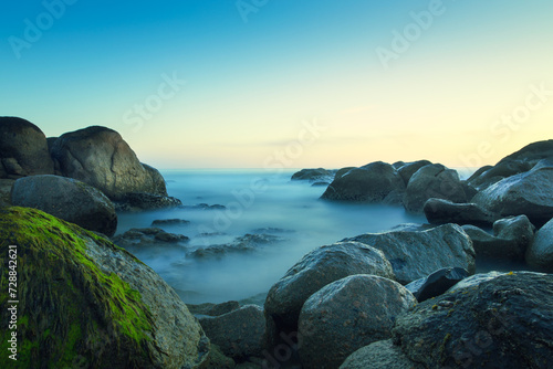 Long exposure by the ocean on a rocky beach. Porto, Portugal