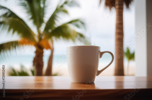 Coffee cup on table with palm tree and sea background.