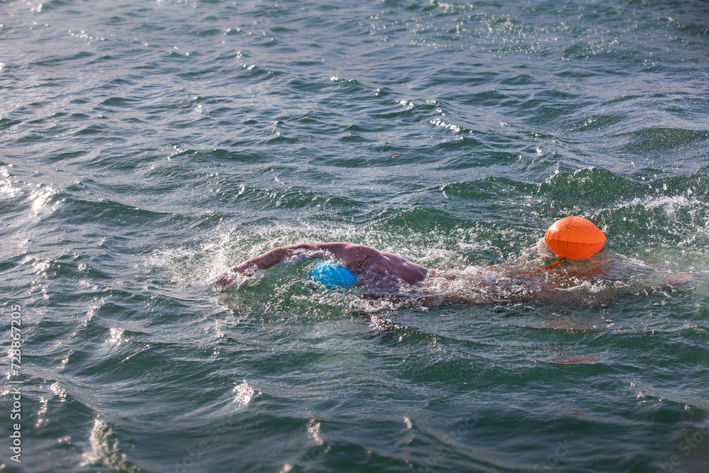 A swimmer in open water, open water swimming, winter swimming, swimming competition, swimming race