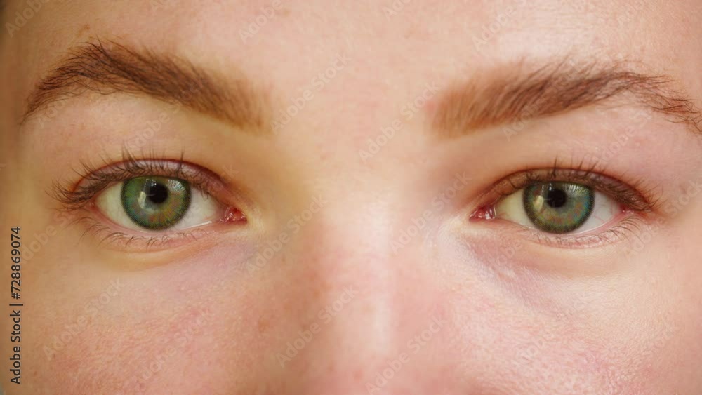 Close-up of a green eyes blinking, opening and closing. Advertising of everyday contact lenses for vision improvement. Optical shop, health care and medicine concept. Close-up of a green eyes blinking, opening and closing. Advertising of everyday contact lenses for vision improvement. Optical shop, health care and medicine concept.