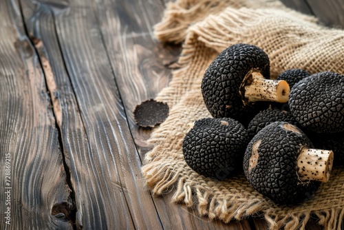 Selective focus on rustic wooden table with free text space featuring black truffle mushrooms