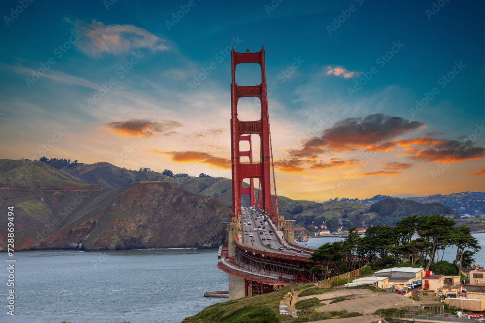 The Golden Gate Bridge over the bay with mountains and lush green trees, plants and grass at the Presidio National Park in San Francisco California USA The Golden Gate Bridge over the bay with mountains and lush green trees, plants and grass at the Presidio National Park in San Francisco California USA