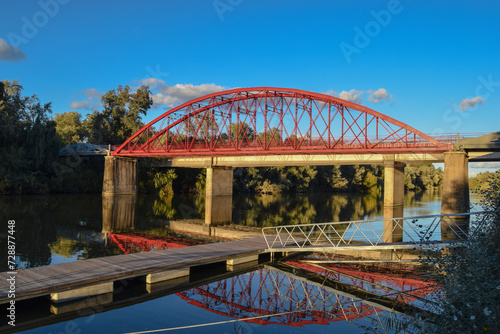 Puente rojo con embarcadero sobre río Guadalquivir