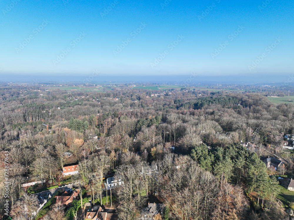 Obraz premium Aerial view of houses surrounded by forest and farmland in the country side area of Walloon, Belgium, Europe