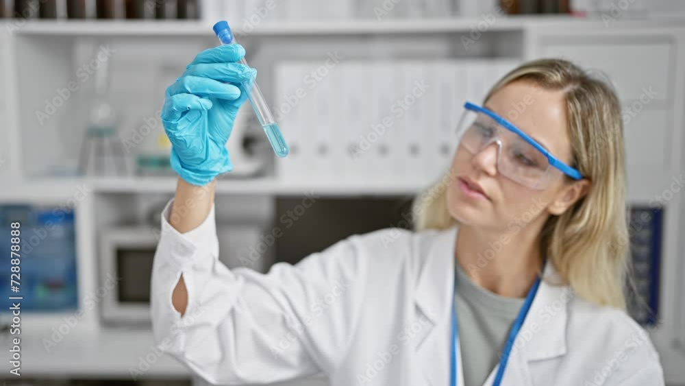 A focused woman scientist examines a test tube in a laboratory setting, showcasing research, technology, and healthcare. A focused woman scientist examines a test tube in a laboratory setting, showcasing research, technology, and healthcare.