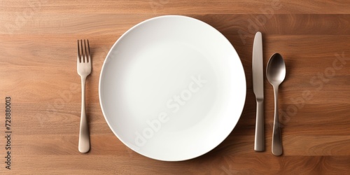 Top view of a white wooden table with empty plate and cutlery.