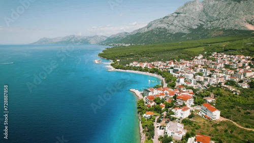 Vibrant Bayside Town on Croatian Coast. Aerial view of bustling town beside the clear turquoise sea waters. Makarska Riviera city. photo