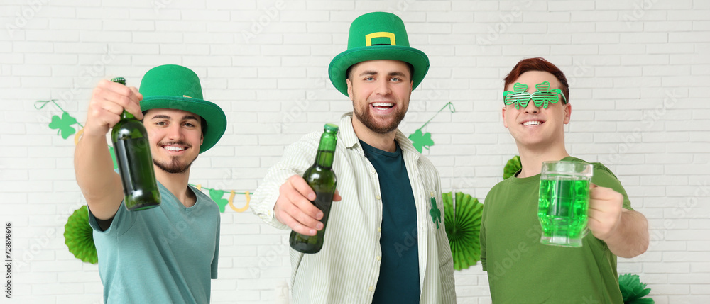 Happy young men with green beer on light background. St. Patrick's Day celebration Happy young men with green beer on light background. St. Patrick's Day celebration