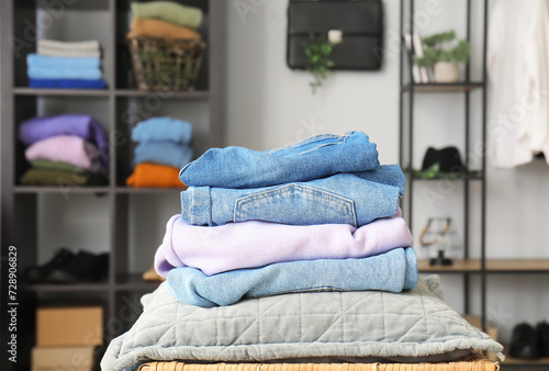 Stack of stylish clothes on table in wardrobe at home © Pixel-Shot