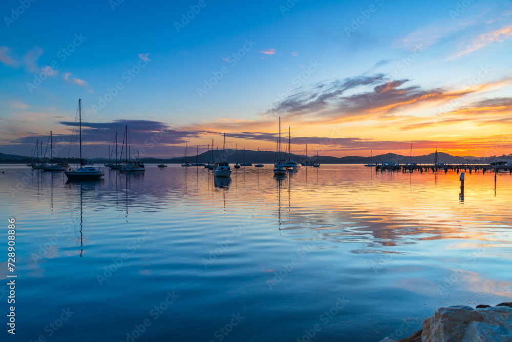 Obraz premium Sunrise, boats and reflections on the water