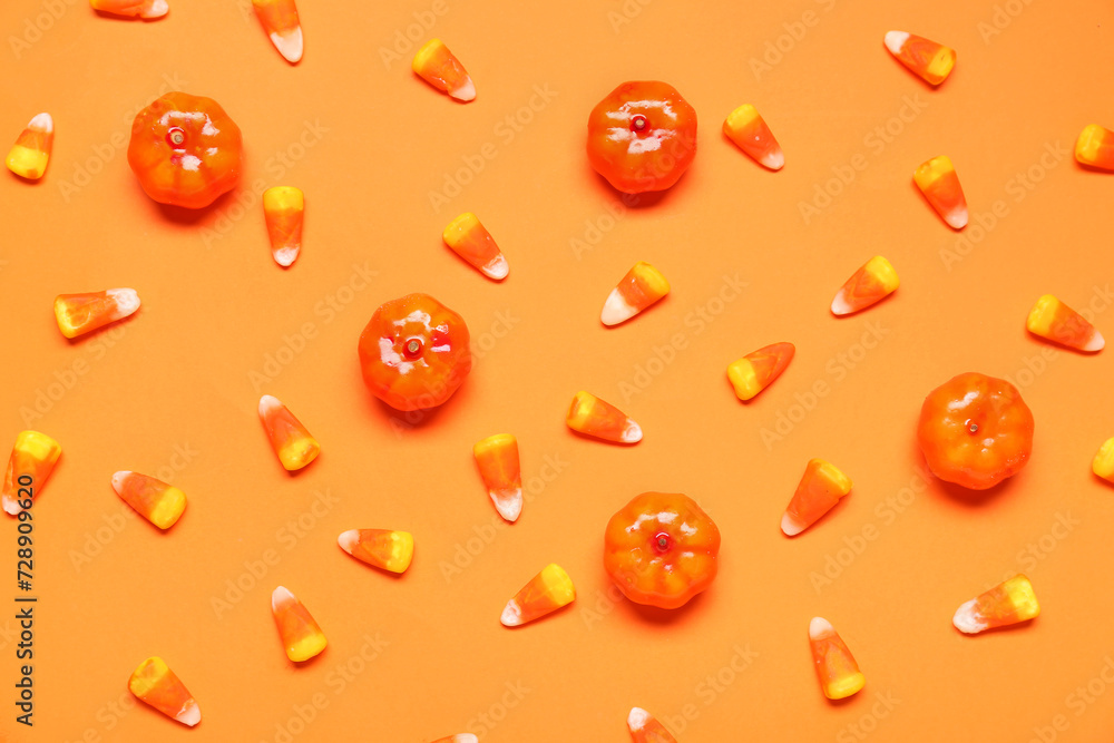 Candy corns and pumpkins on orange background Candy corns and pumpkins on orange background