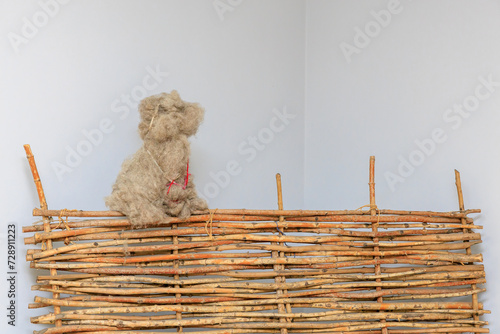 Wool collected in the shape of a dog on a decorative rustic fence. Background with selective focus and copy space photo