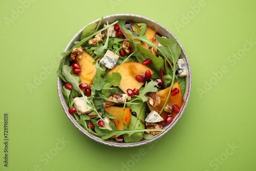 Photography Tasty salad with persimmon, blue cheese, pomegranate and walnuts served on light