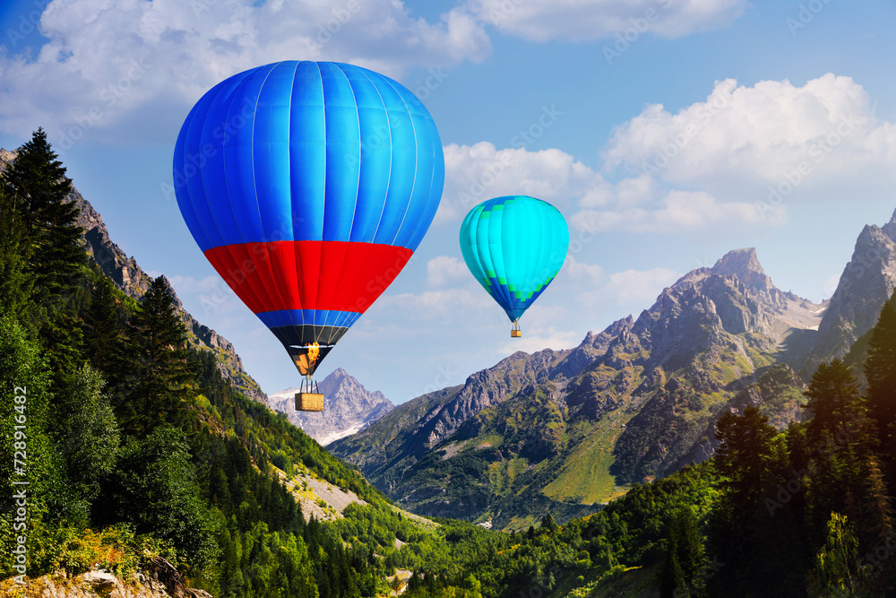 Bright hot air balloons flying over mountains