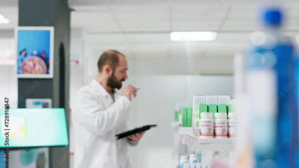 Medical worker counting medicaments boxes placed on shelves, working on drugstore inventory to ensure full stock for clients. Pharmacist doing logistical activity with packages of pills. Medical worker counting medicaments boxes placed on shelves, working on drugstore inventory to ensure full stock for clients. Pharmacist doing logistical activity with packages of pills.