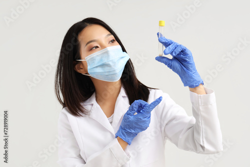 Asian woman in medical glov...