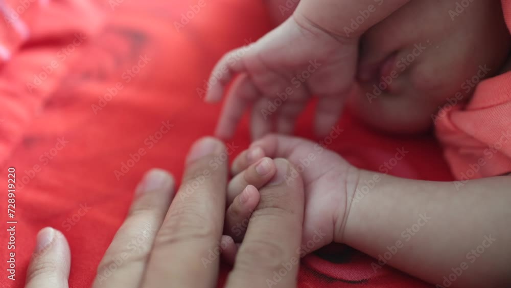 New born baby hand holding father hand during baby sleeping. newborn baby and dad hands. father taking care of his daughter kid happy family dream of health New born baby hand holding father hand during baby sleeping. newborn baby and dad hands. father taking care of his daughter kid happy family dream of health