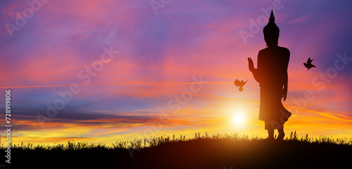 Silhouette of Buddha mediating in the twilight with sunrise background. Buddhist holiday Concept. © Peachayatanomsup
