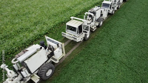 High Resolution Video of several Vibro-Trucks shot with a drone. It shows the trucks driving on a field, while the drone is flying above them. photo